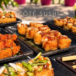 Plateaux de sushis frits variés présentés sur des assiettes noires dans un restaurant japonais