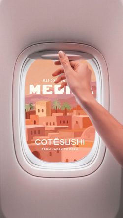 Logo Côté Sushi visible à travers la fenêtre d'un avion avec décor méditerranéen en arrière-plan.