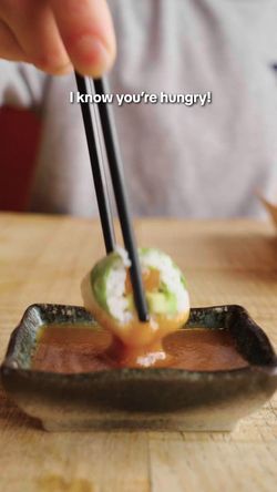 Sushi à emporter trempé dans une sauce dans un restaurant japonais avec livraison à Quimper.