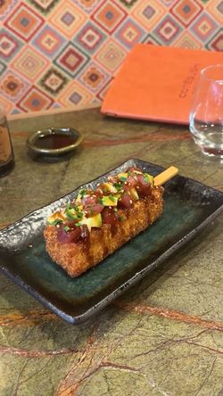 Brochette de sushi frit garnie de poisson cru et d'herbes servie dans un restaurant japonais