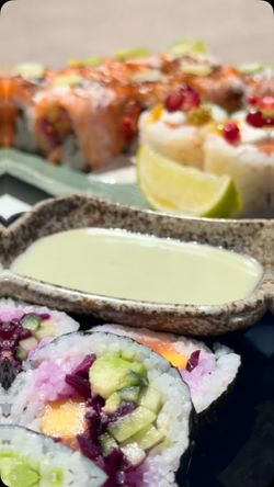 Sushis variés accompagnés d'une sauce dans un restaurant japonais proposant livraison et plats à emporter.