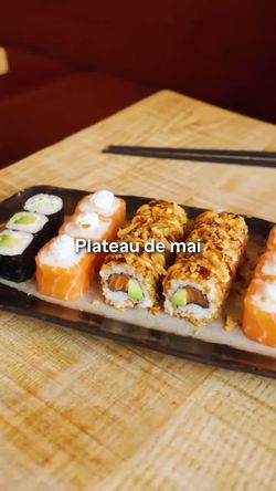 Assortiment de sushi variés sur un plateau, comprenant maki, sushi au saumon et rouleaux croustillants, prêt à emporter.