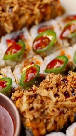 Sushis avec sauce et tranches de piment vert servis avec un accompagnement croustillant dans un restaurant japonais.