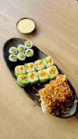 Plateau de sushis variés avec sauce à côté, dans un restaurant japonais de sushis à emporter.