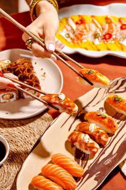 Sushis variés et plats japonais préparés pour emporter, servis avec des baguettes et sauce soja dans un restaurant japonais.
