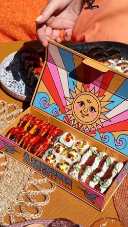 Boîte colorée de sushis variés avec sauces, prête à emporter dans un restaurant japonais à Tours.