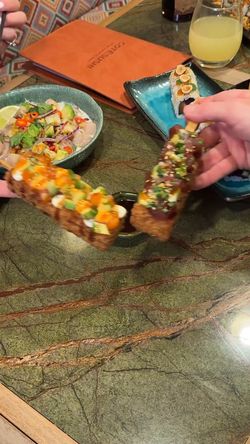 Deux plats de sushi et une salade colorée sur une table en marbre au restaurant japonais Côté Sushi Wasquehal.