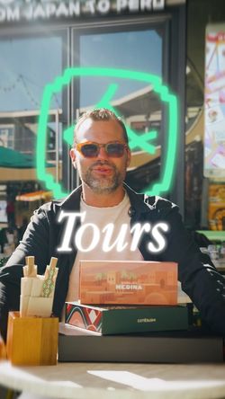 Homme assis avec des boîtes de sushi devant un restaurant japonais Côté Sushi Tours