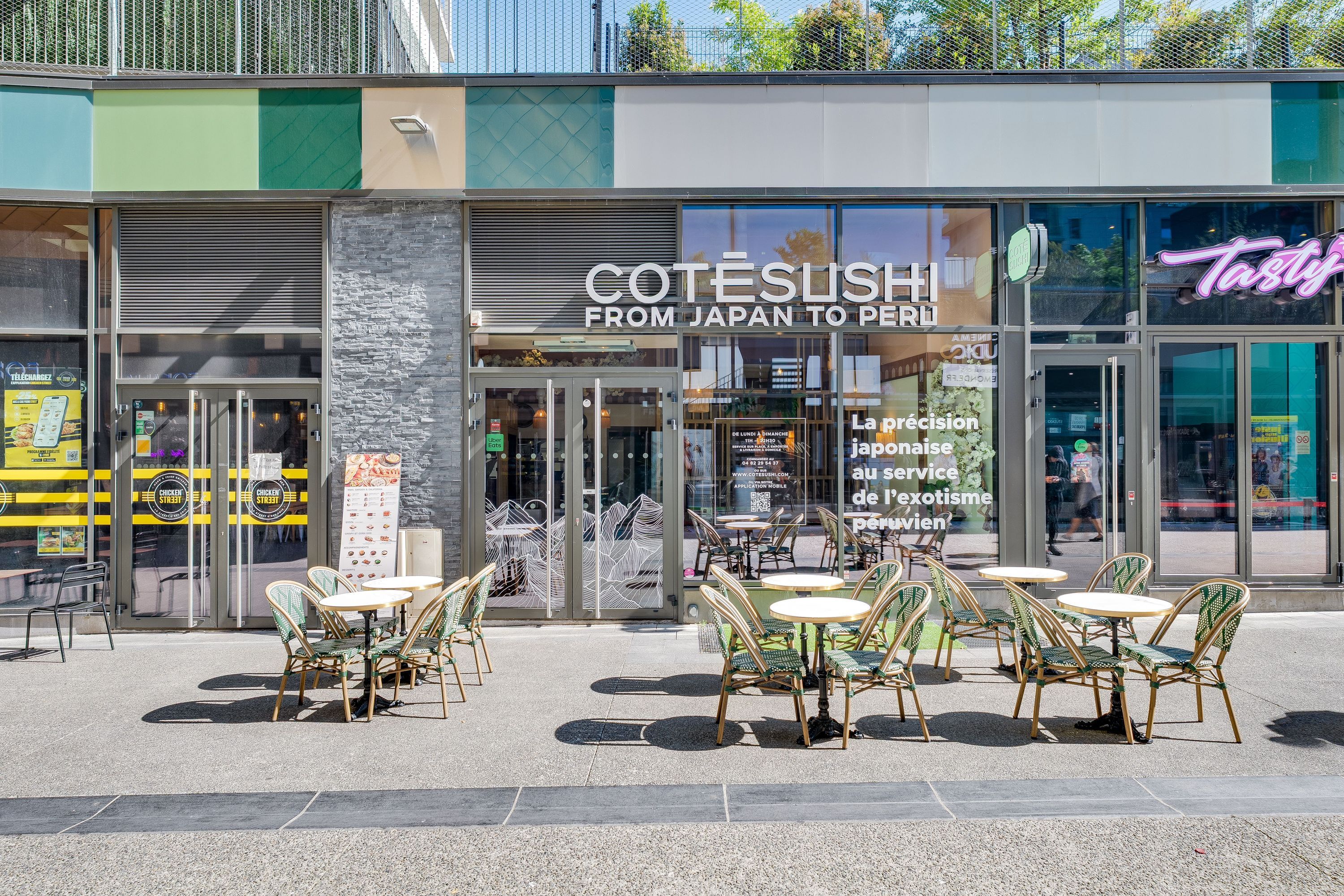 Façade moderne de Côté Sushi Annemasse avec tables extérieures et menu visible pour livraison et emporter