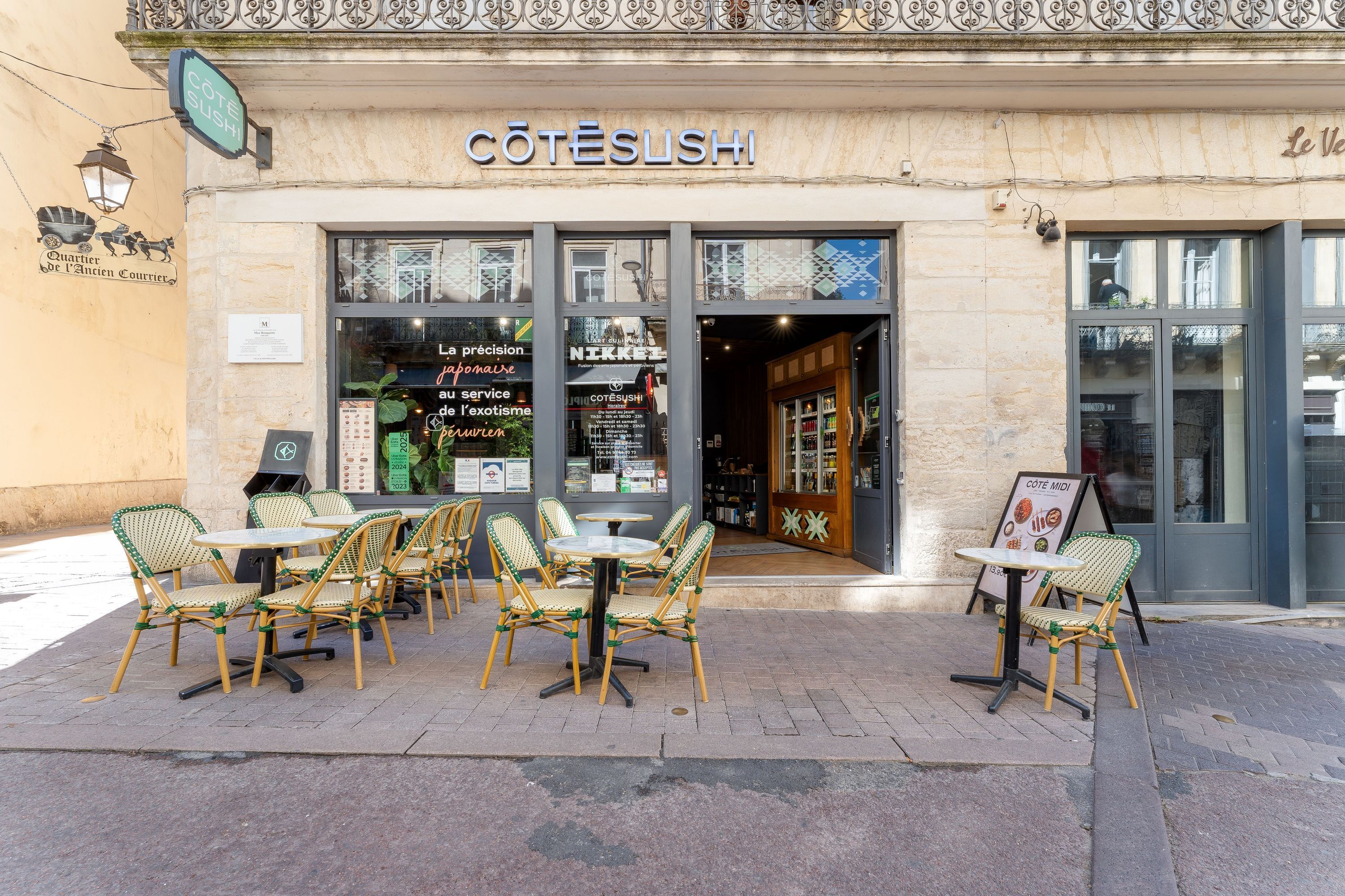 Façade de Côté Sushi Montpellier Ecusson avec terrasse extérieure et tables en rotin vert et jaune