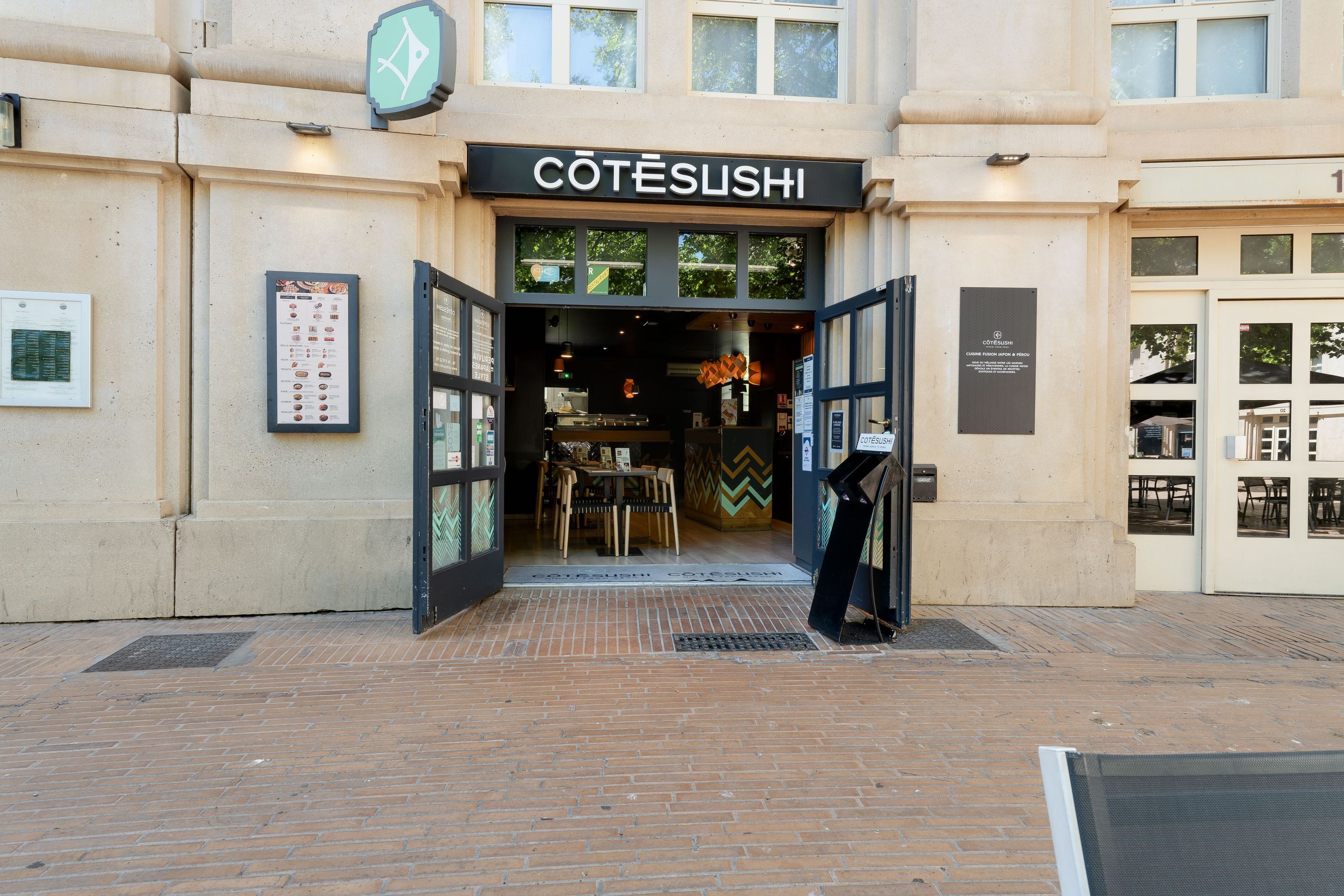 Entrée ouverte du restaurant japonais Côté Sushi Montpellier Antigone avec portes vitrées et menu affiché à l'extérieur