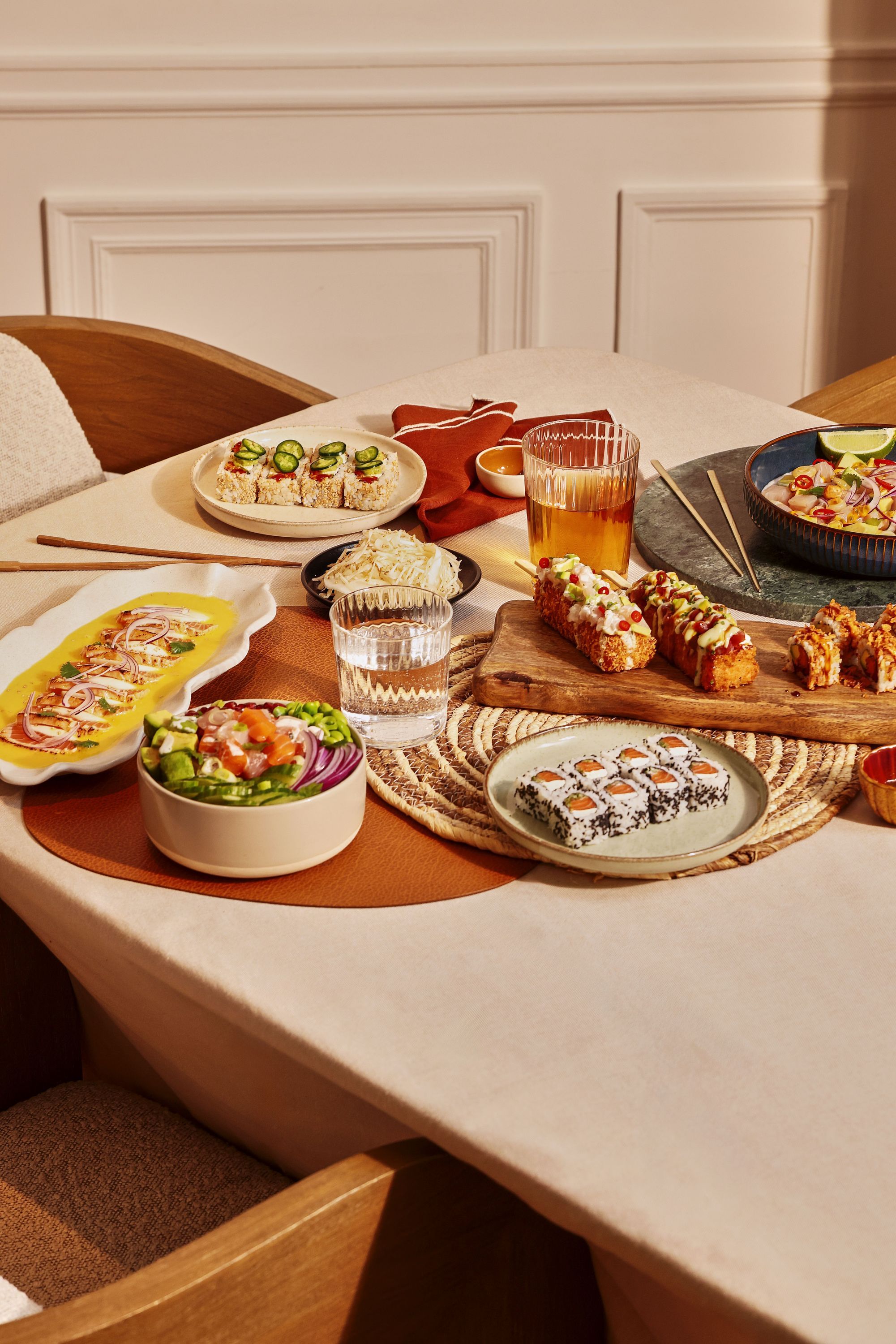 Assortiment de sushis et plats japonais variés avec boissons sur une table au restaurant japonais Coté sushi Aix les Bains.