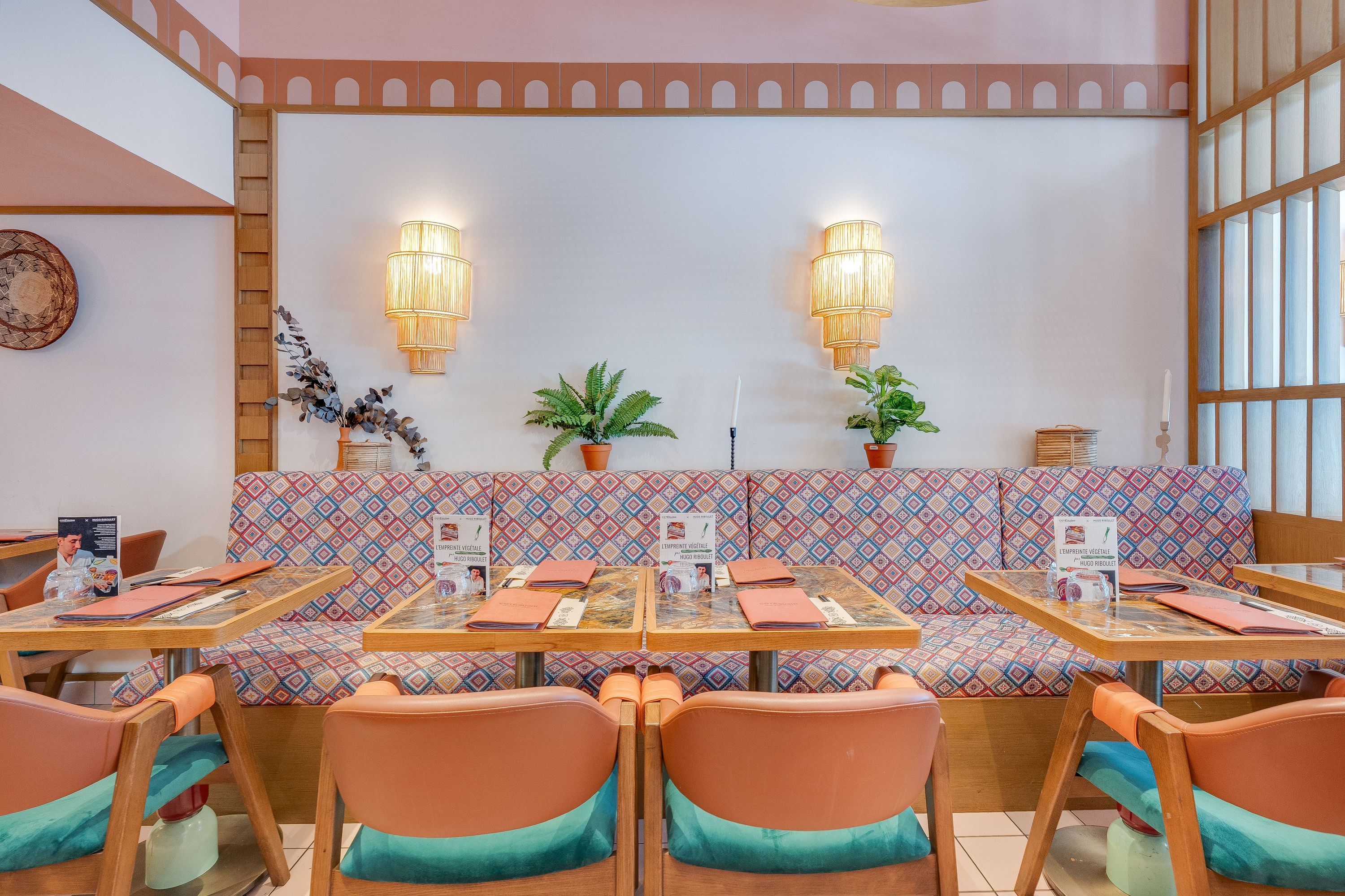 Salle lumineuse de restaurant japonais avec tables en bois et banquette colorée prête pour service