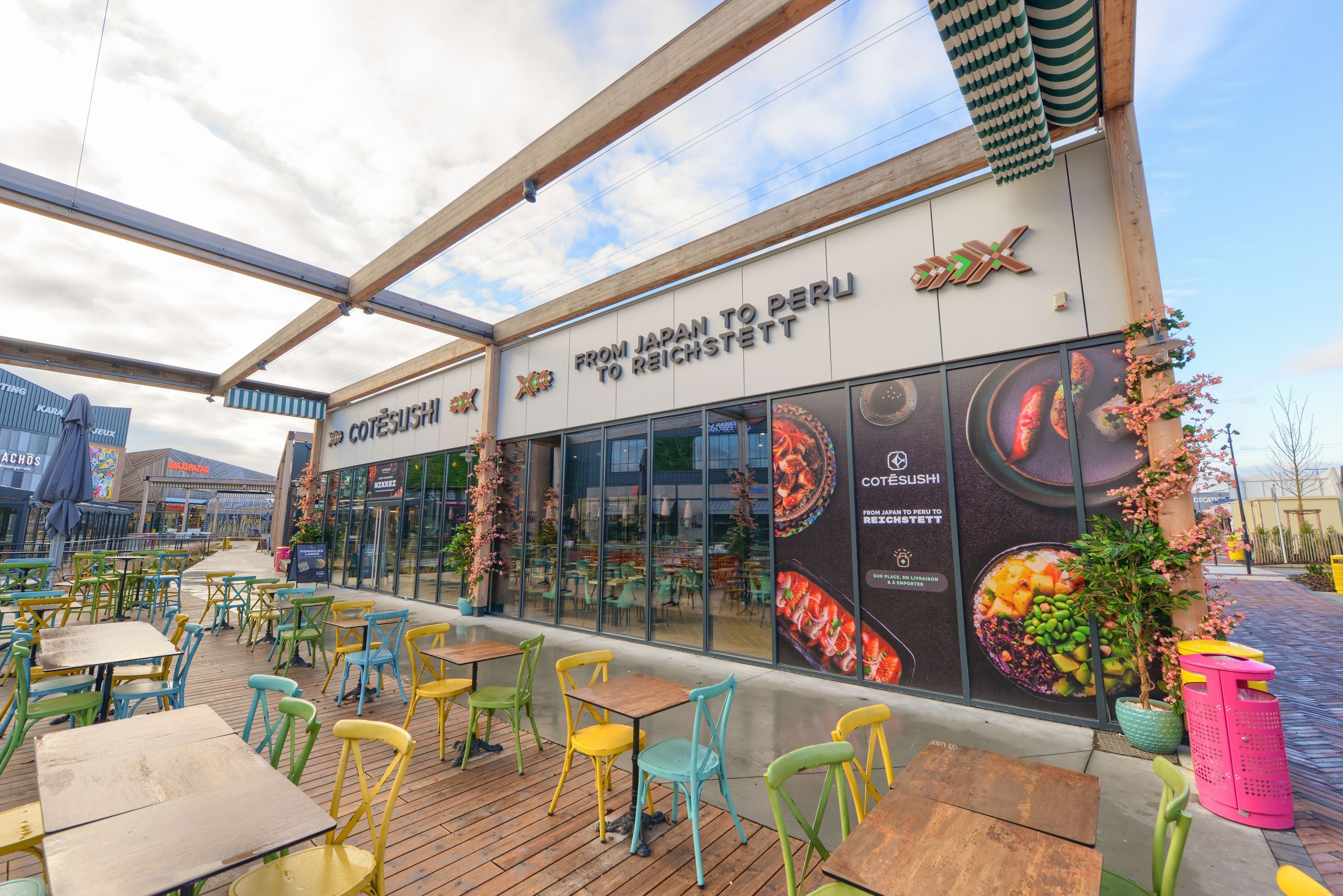 Terrasse extérieure avec tables et chaises colorées devant le restaurant japonais Côté Sushi Strasbourg Reichstett