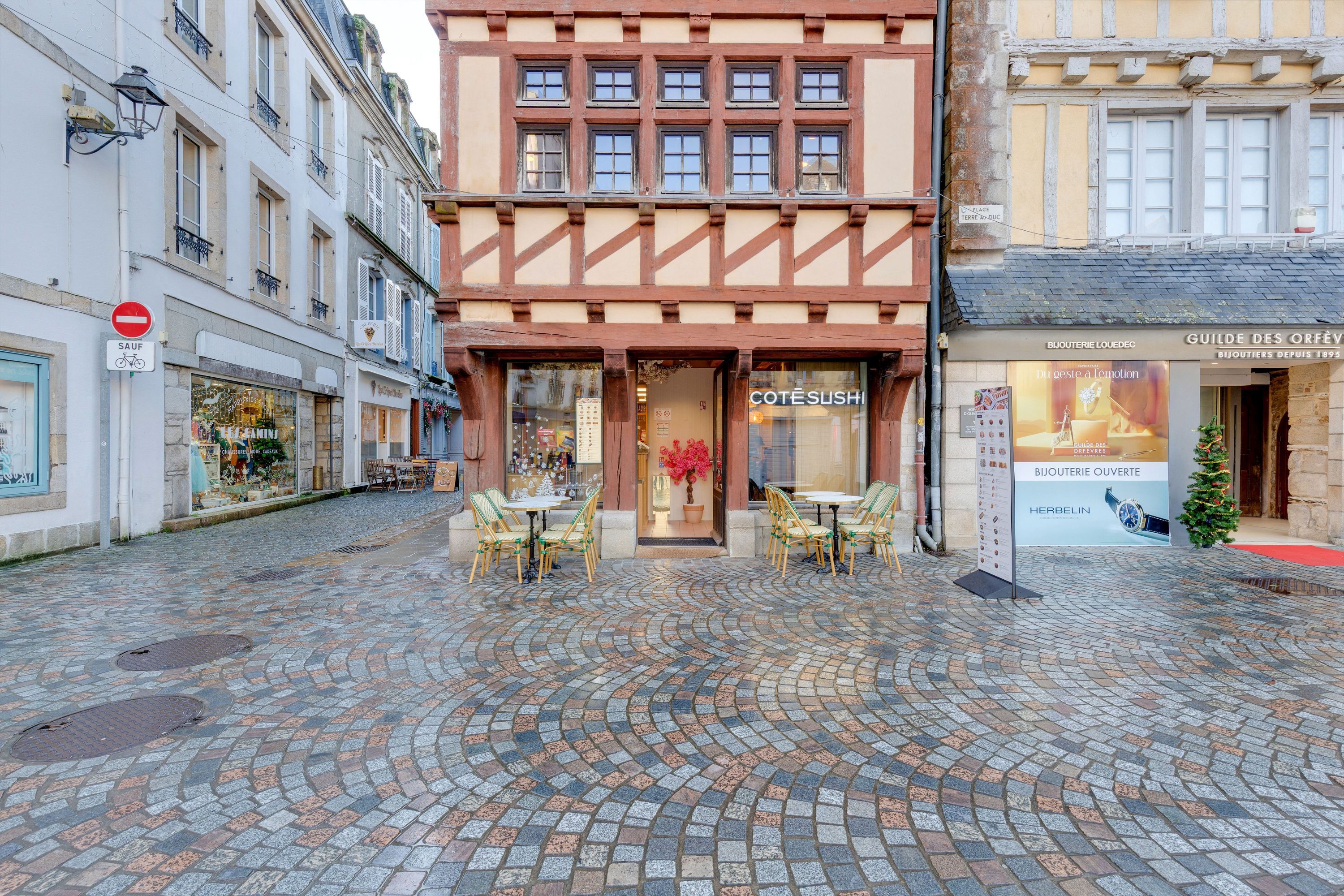 Façade de Côté Sushi Quimper avec terrasse extérieure sur pavés dans une rue piétonne historique.