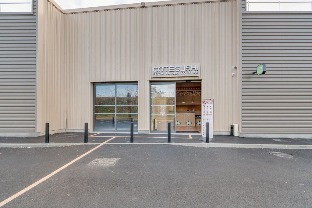 Façade du restaurant japonais Côté Sushi Manosque avec entrée vitrée et panneau lumineux visible depuis le parking