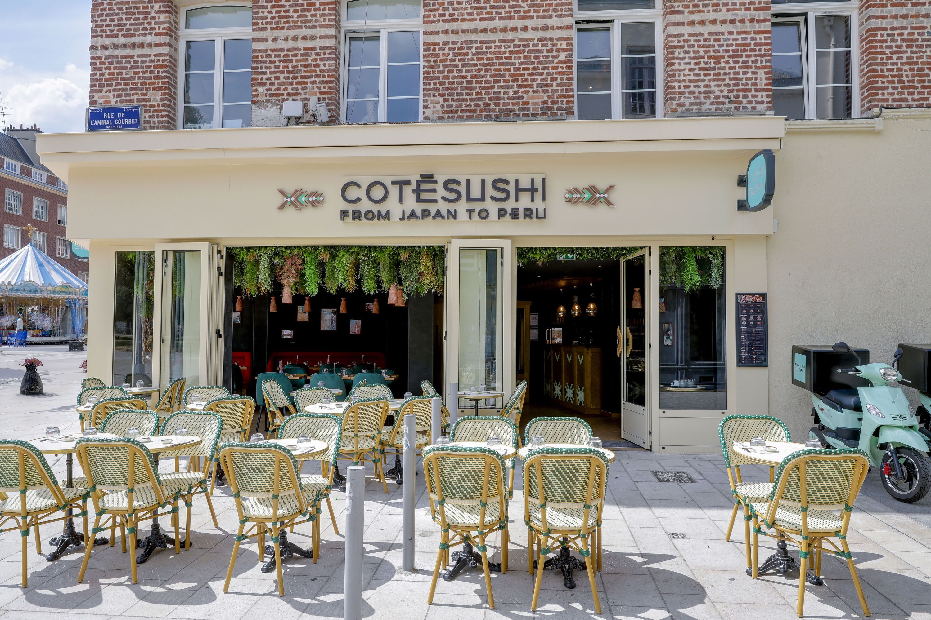 Façade du restaurant Côté Sushi Amiens avec terrasse extérieure et chaises en osier vertes et blanches