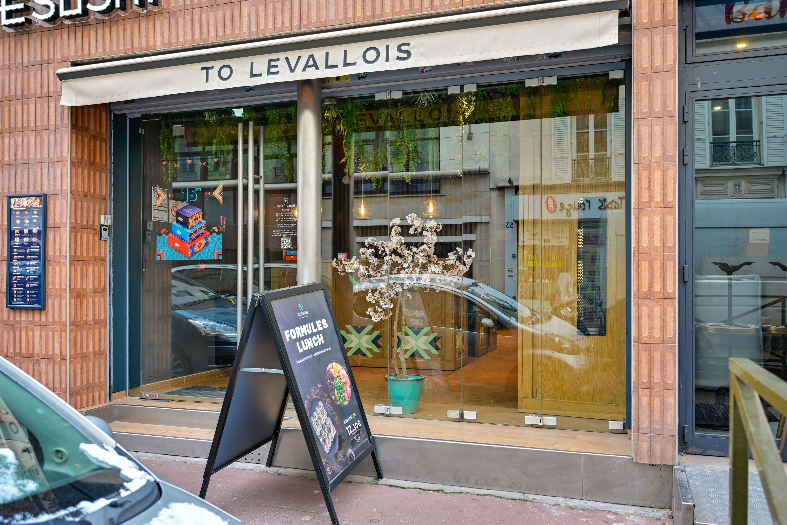 Façade du restaurant japonais Côté Sushi Levallois-Perret avec affichage des formules lunch et décoration intérieure visible.