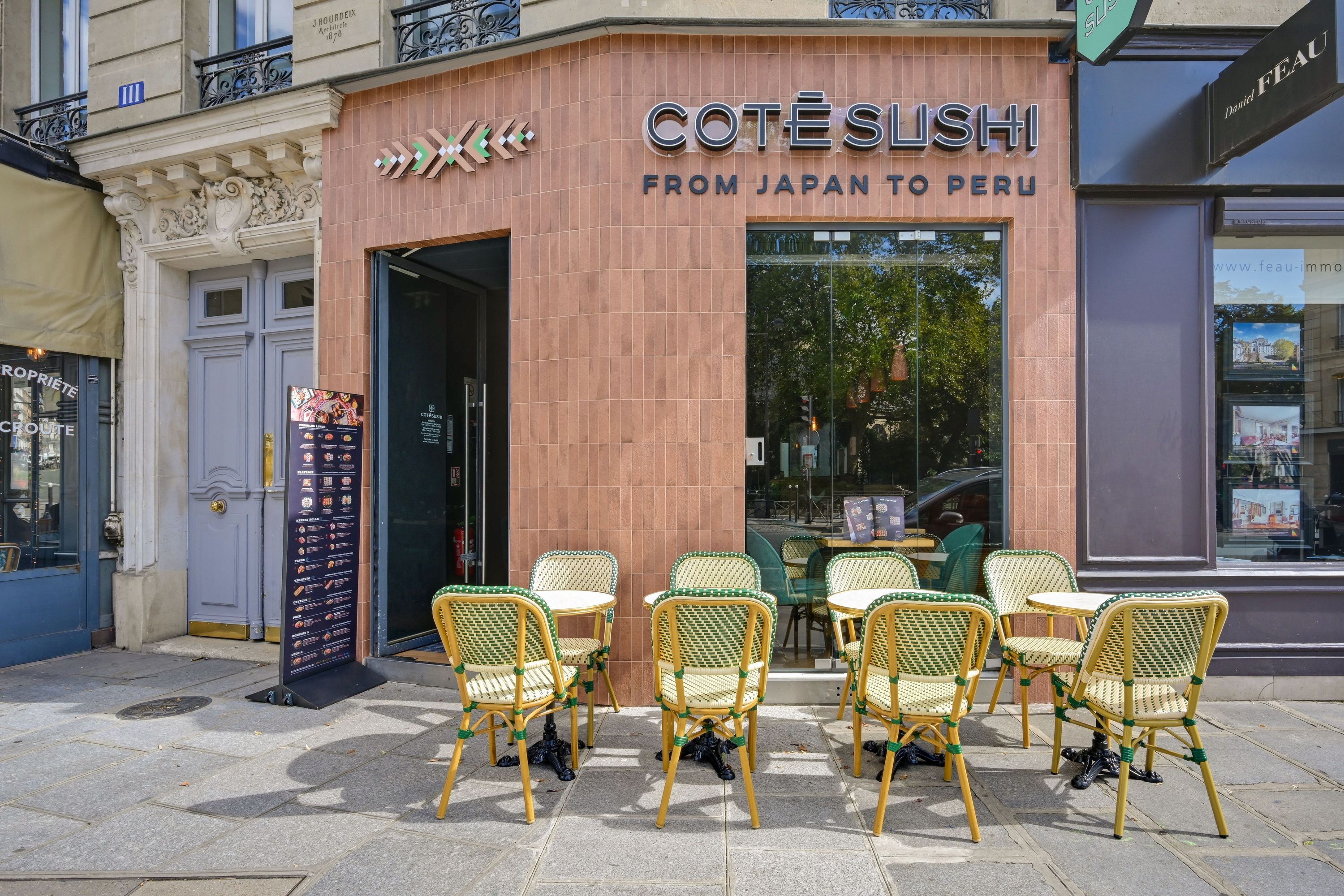 Terrasse avec chaises et tables devant le restaurant de sushis Côté Sushi Monge sur une rue pavée