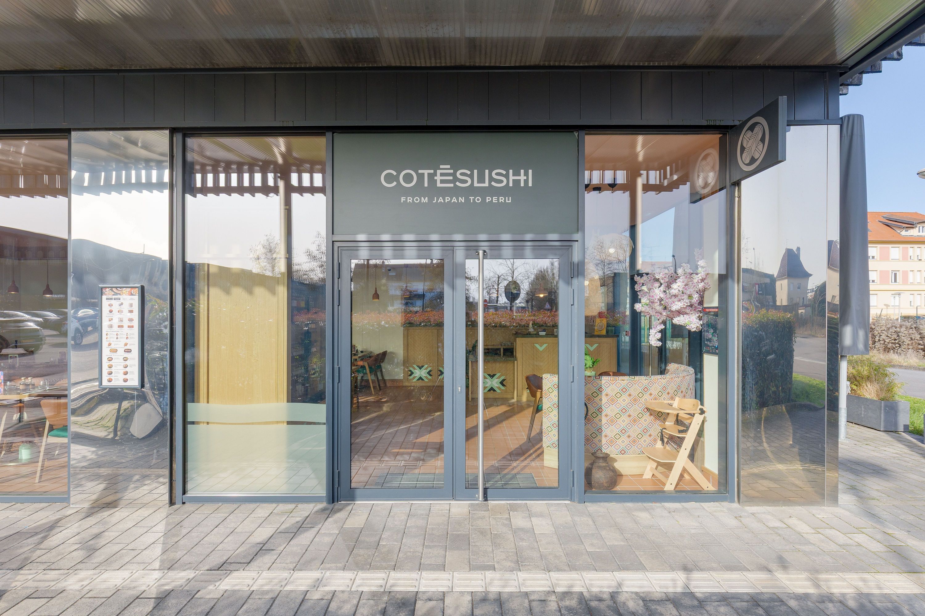 Façade moderne du restaurant japonais Côté Sushi Thionville avec porte en verre et décoration intérieure visible
