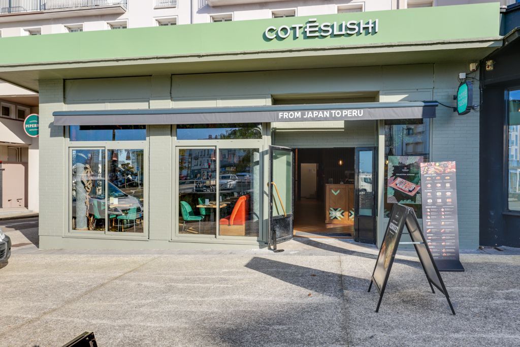 Façade verte du restaurant japonais Côté Sushi Brest avec vitres, enseigne lumineuse et menu à l'entrée
